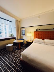 芝加哥L7 Chicago by LOTTE的酒店客房配有一张床铺和一张桌子。