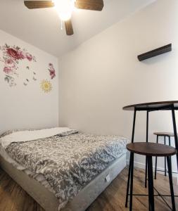 圣让上黎塞留welcome to airbnb的一间卧室配有一张带桌子和两张凳子的床