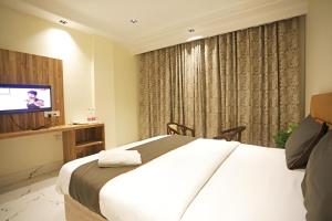 新德里Hotel GOOD LUCK HOUSE Near Delhi Airport的酒店客房,配有床和电视