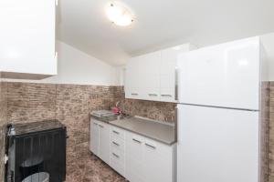 蒂瓦特Hillside Vista Apartments的白色的厨房配有水槽和冰箱