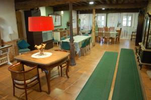 ValdealvilloPosada Casa Juanes的一间带桌椅和红灯的用餐室