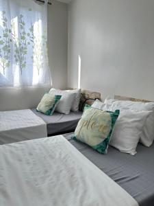 伊洛伊洛Casa Mia at SMDC Styles Residence Tower A的客房设有两张带白色床单和枕头的床。