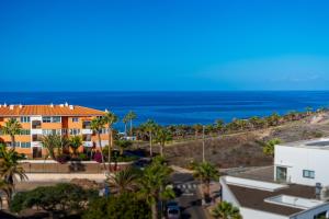 吉亚德伊索拉Green House - Modern Villa in Tenerife, Spain的一座以海洋为背景的橙色建筑