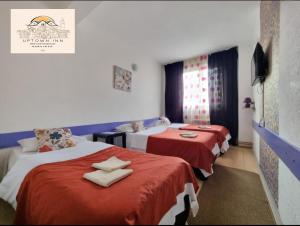 萨拉热窝Uptown Inn的酒店客房,配有两张带红色床单的床