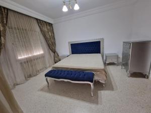 突尼斯Dar Salem III的一间卧室配有一张大床和蓝色长凳