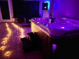 Flémalle-GrandeLes bulles d'or的紫色浴室设有浴缸,地板上设有灯光