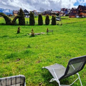 穆扎希赫尔ECO Domek z dużym ogrodem i widokiem的坐在草地上的椅子