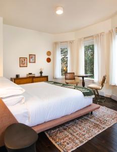 普莱西德湖Eastwind Hotel Lake Placid的卧室设有白色大床和窗户。