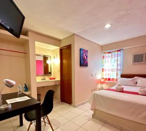坎佩切巴兰基亚酒店的一间卧室配有一张床、一张书桌和一台电视