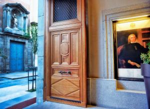 马德里帕拉西奥特帕NH精选酒店的通向一座建筑物的门,上面有一张男人的照片
