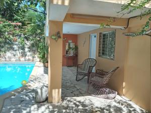 博卡奇卡Villa rozenuda的一个带两把椅子的庭院和一个游泳池