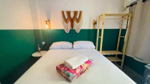 萨尔瓦多Sunflower Hostel的一间卧室配有一张白色的床和绿色的墙壁