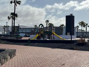 普拉亚布兰卡Las Brisas, Villa 98的棕榈树公园内一个带滑梯的游乐场