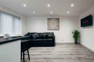 利物浦Park & Relax in 1bd Central Liverpool home的客厅配有黑色真皮沙发