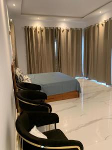 科托努Luxe Dandji的一间卧室,卧室内配有一张床和椅子