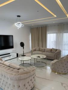 科托努Luxe Dandji的带沙发和平面电视的客厅