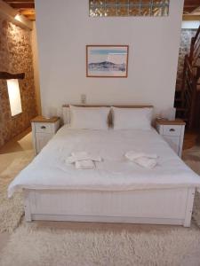卡拉莫斯KALAMOS PLAZA的卧室配有白色的床和2条毛巾