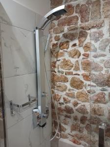 卡拉莫斯KALAMOS PLAZA的带淋浴的浴室(带石墙)