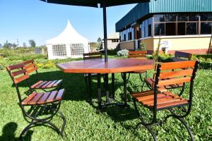 NguluniKoma Gardens and Resort的一张带两把椅子和一把伞的野餐桌