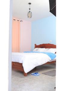 NguluniKoma Gardens and Resort的一间卧室设有两张床和一对拖鞋。