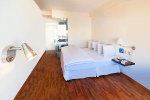拉巴斯LP哥伦布酒店的卧室配有白色的床,铺有木地板