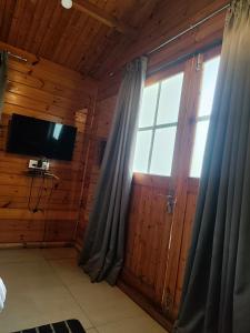莫尔吉姆Seawood beach front resort的客房设有电视和带窗帘的窗户。