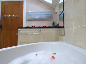 埃斯克代尔Renovated 5 Bedroom Farmhouse in Picturesque Eskdale, Lake District的浴室内装有浴缸,内配食物