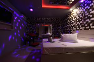 里梅拉Motel Deslize Limeira 3的紫色灯房内的一张床