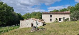 Roullet-Saint-EstèpheUn gîte en Charente, gîte 4 étoiles的一座位于草地山上的古老石头建筑