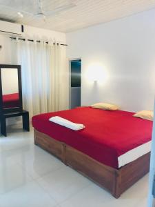 波隆纳鲁沃New hotel canel park的一间卧室配有一张带红色毯子的大床