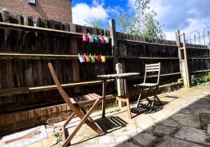 伦敦Cute Studio Garden Flat, 5 min to tube的围栏旁的一张桌子和两把椅子