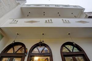 克久拉霍Super OYO Madpackers Khajuraho的一座带两扇窗户和白色天花板的建筑