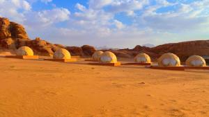 瓦迪拉姆Wadi Rum Ali Bubble camp的沙漠中一排岩石的圆顶