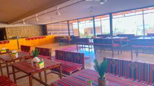 瓦迪拉姆Wadi Rum Ali Bubble camp的一间空餐厅,配有桌椅和窗户