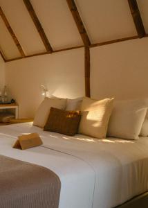 马塔迪圣若昂Blue praia de Santo Antônio的一间卧室配有带白色床单和枕头的床。