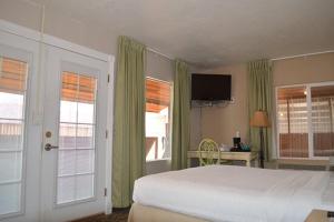 Mexican HatMexican Hat Lodge的卧室配有床、电视和窗户。