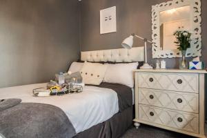 克罗索恩Oasis in English Village的一间卧室配有一张带梳妆台和镜子的床
