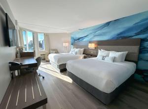 纳奈莫海滨堡垒酒店的酒店客房设有两张床,墙上挂有蓝色画作。