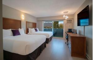 伯纳比Coast Metro Vancouver Hotel的酒店客房设有两张床和电视。