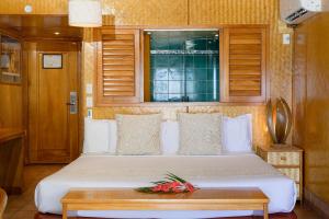 拉罗汤加圣拉罗汤加海滩酒店（仅限成人）的一间卧室配有一张带桌子和窗户的床