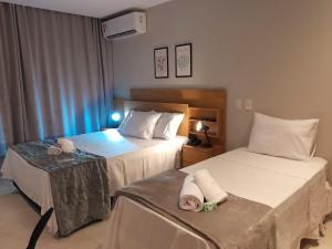 坎普斯戈伊塔卡济斯APART HOTEL AMÉRICA的酒店客房,配有两张带毛巾的床