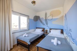 米尔芳提斯城MUTE Hostel Milfontes的蓝色墙壁客房的两张床