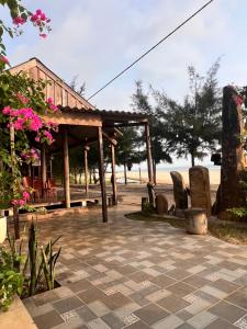 Hoằng LễHomestay view biển的庭院中一个带椅子和鲜花的凉亭