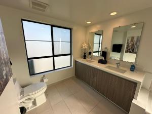 洛杉矶The Century City Cozy 3 Bedroom Apartment with free parking!的一间带卫生间、水槽和镜子的浴室