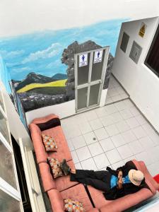 瓦拉斯Sunrise Guest House的一位女士躺在地板上,在一间有画作的房间