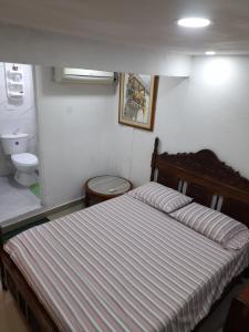 卡塔赫纳Hostal Casa de las Americas的一间卧室配有一张床和一个卫生间