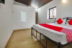 巴加OYO Pratisha Guest House的一间卧室配有一张带红色枕头的大床