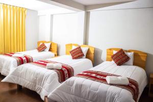 Comunidad YumaniInti kala lodge的带3张白色床单的床的房间