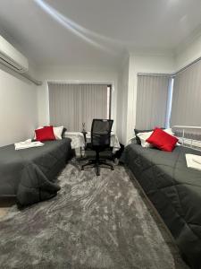 卧龙岗Private Room in Townhouse的客厅配有两张沙发和一把椅子