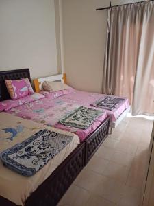 艾因苏赫纳Lasirena Resort Aqua Park-Family Only的两张睡床彼此相邻,位于一个房间里